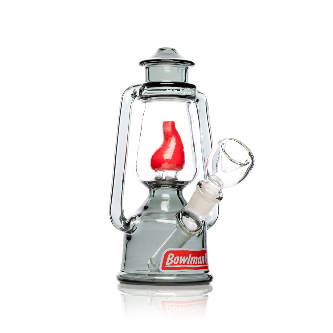A studio shot of the Bowlman Lantern Bong, showcasing its clear glass construction and unique lantern-inspired shape. A studio shot of the Bowlman Lantern Bong, showcasing its clear glass construction and unique lantern-inspired shape.