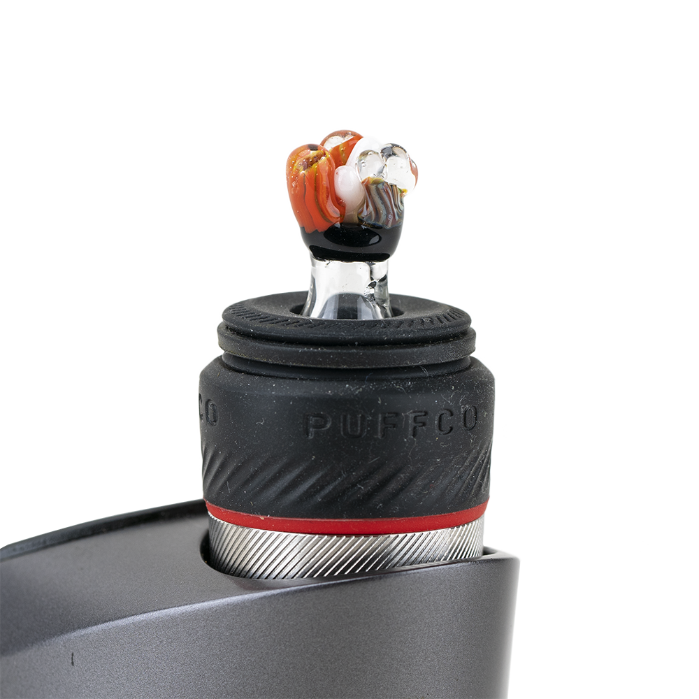 A close-up shot of the Coral PuffCo Peak Pro Glass Ball Cap, highlighting its rounded shape and reflective surface. A close-up shot of the Coral PuffCo Peak Pro Glass Ball Cap, highlighting its rounded shape and reflective surface.