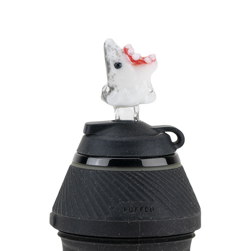 A close-up, angled shot of the Jawsome PuffCo Proxy Glass Ball Cap, showcasing its clear glass construction and spherical shape. A close-up, angled shot of the Jawsome PuffCo Proxy Glass Ball Cap, showcasing its clear glass construction and spherical shape.