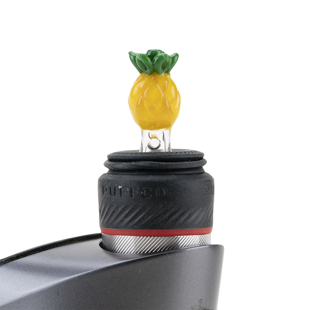 A close-up, angled view of the Pineapple PuffCo Peak Pro Glass Ball Cap, showcasing its colorful, rounded design. A close-up, angled view of the Pineapple PuffCo Peak Pro Glass Ball Cap, showcasing its colorful, rounded design.