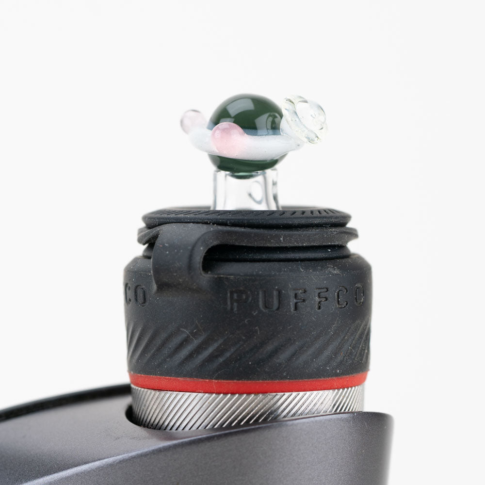 Close-up of the Galaxy PuffCo Peak Pro Glass Ball Cap, showing its spherical shape and reflective surface against a dark backdrop. Close-up of the Galaxy PuffCo Peak Pro Glass Ball Cap, showing its spherical shape and reflective surface against a dark backdrop.