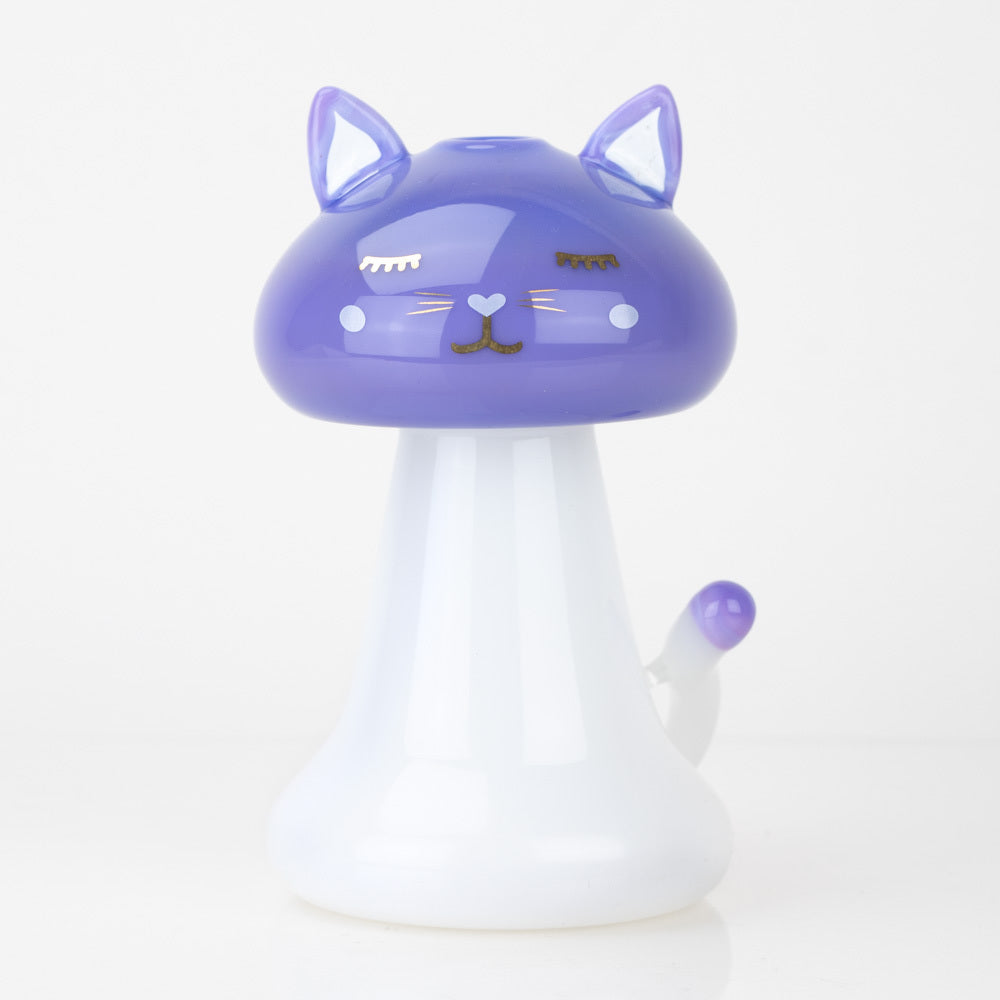 Front view of the SakiBomb Shroom Kitty Mini Rig, a small, purple glass piece with a rounded shape and smooth, reflective surface. Front view of the SakiBomb Shroom Kitty Mini Rig, a small, purple glass piece with a rounded shape and smooth, reflective surface.
