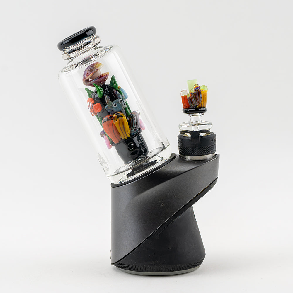 A close-up, angled view of the Save the Seas PuffCo Peak & Peak Pro Glass Attachment, showcasing its colorful, artistic glass design. A close-up, angled view of the Save the Seas PuffCo Peak & Peak Pro Glass Attachment, showcasing its colorful, artistic glass design.