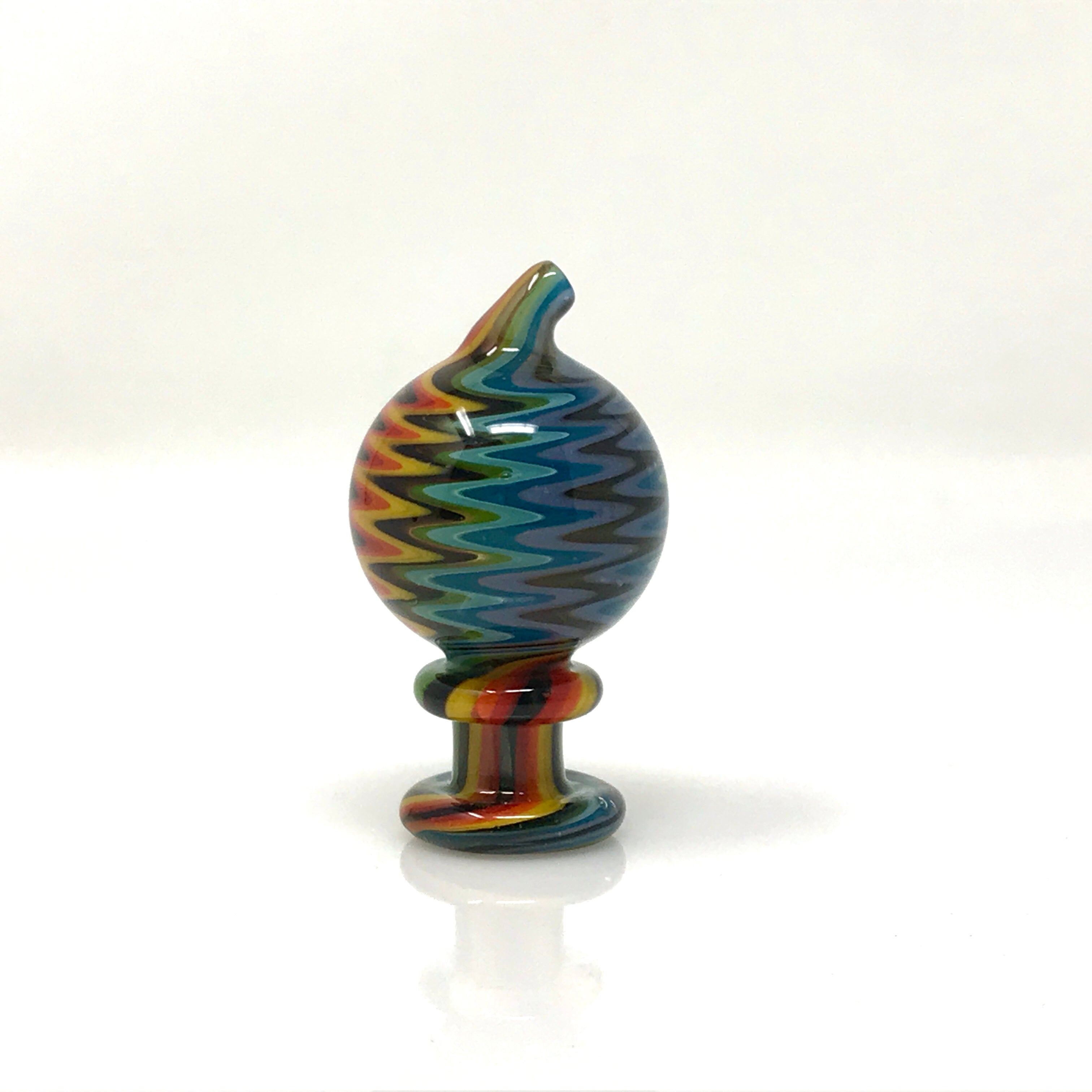 A close-up, angled view of the Directional Full Color Wig Wag Reversal Carb Cap, showing its vibrant, swirled glass design. A close-up, angled view of the Directional Full Color Wig Wag Reversal Carb Cap, showing its vibrant, swirled glass design.