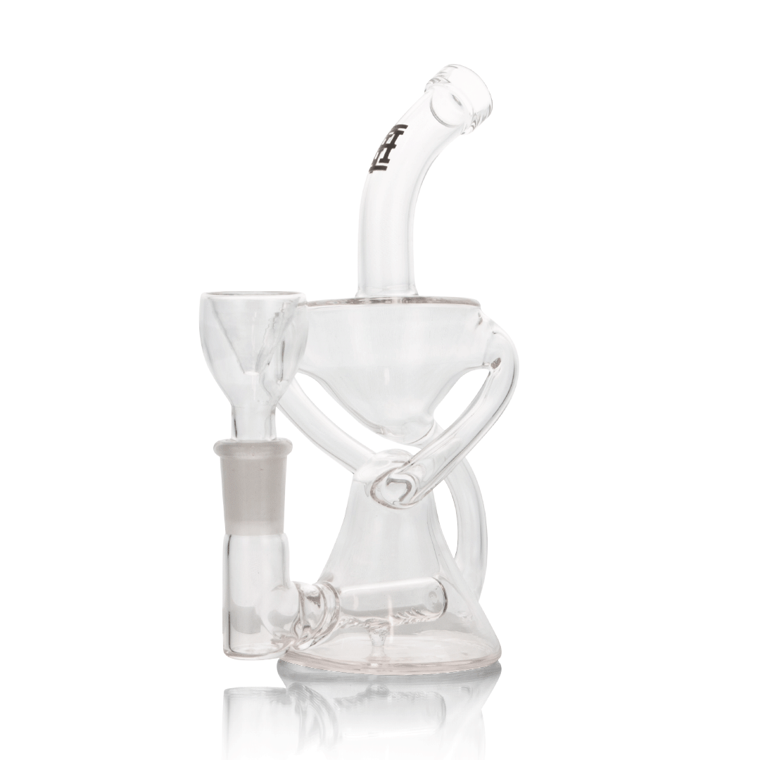 A studio shot displays the Trophy Recycler Rig with a clear glass construction and intricate internal chambers, reflecting light on a polished surface. A studio shot displays the Trophy Recycler Rig with a clear glass construction and intricate internal chambers, reflecting light on a polished surface.