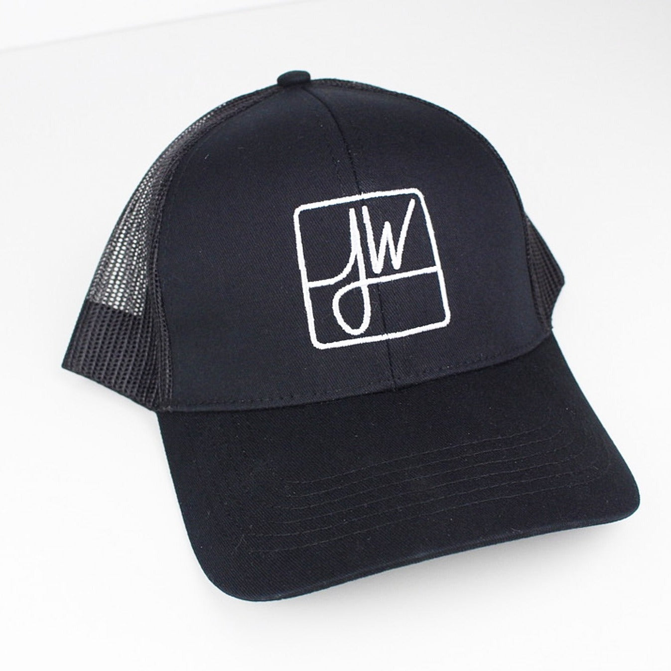 A slightly angled, front view of the Jane West Snapback Hat, showing its black fabric and mesh back against a plain white background. A slightly angled, front view of the Jane West Snapback Hat, showing its black fabric and mesh back against a plain white background.