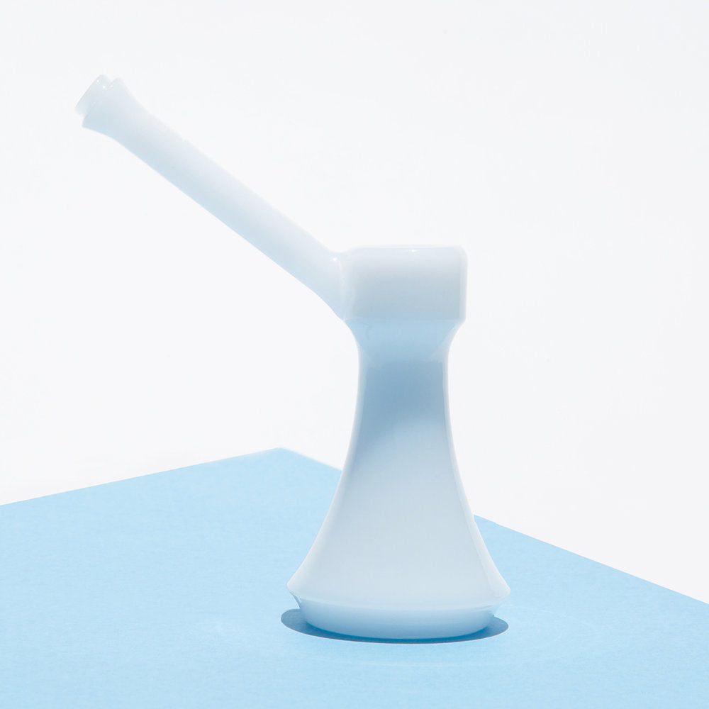 A slightly angled view showcases The Bubbler, its simple form highlighted against a textured, light blue backdrop. A slightly angled view showcases The Bubbler, its simple form highlighted against a textured, light blue backdrop.