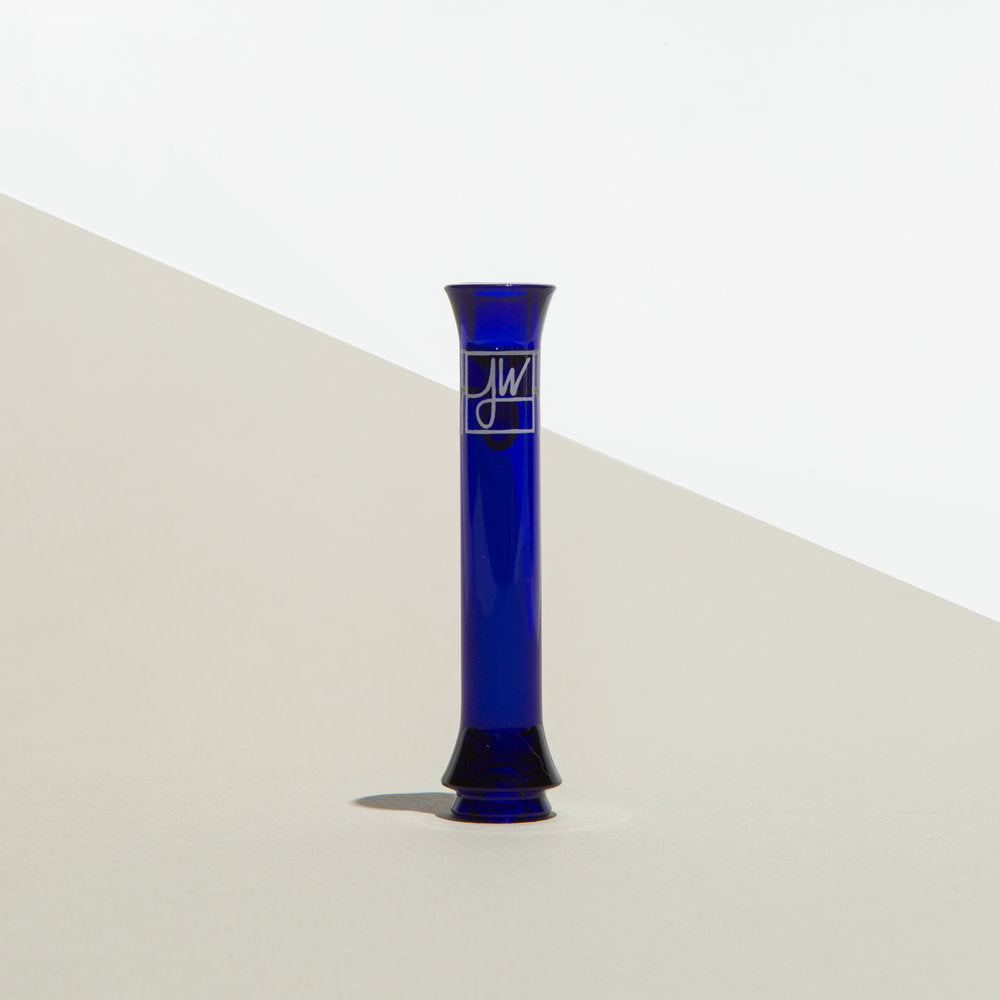 The Taster displays a front view of the uniquely shaped glass piece against a plain, light-grey backdrop. The Taster displays a front view of the uniquely shaped glass piece against a plain, light-grey backdrop.