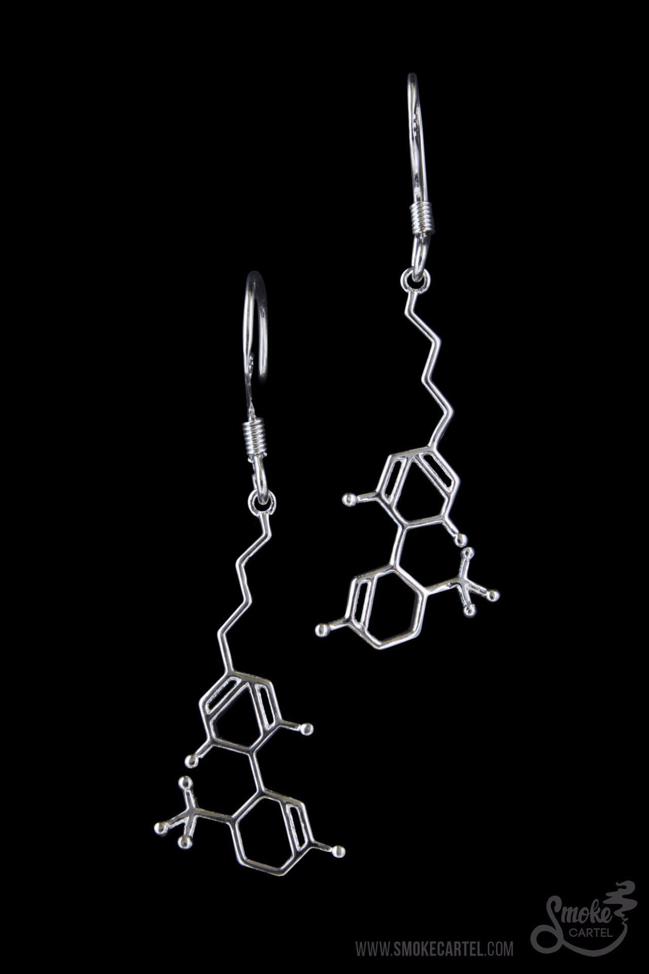 Front view of the SC-THC-EAR-S earrings, featuring a silver, molecular-shaped design against a plain black background. Front view of the SC-THC-EAR-S earrings, featuring a silver, molecular-shaped design against a plain black background.