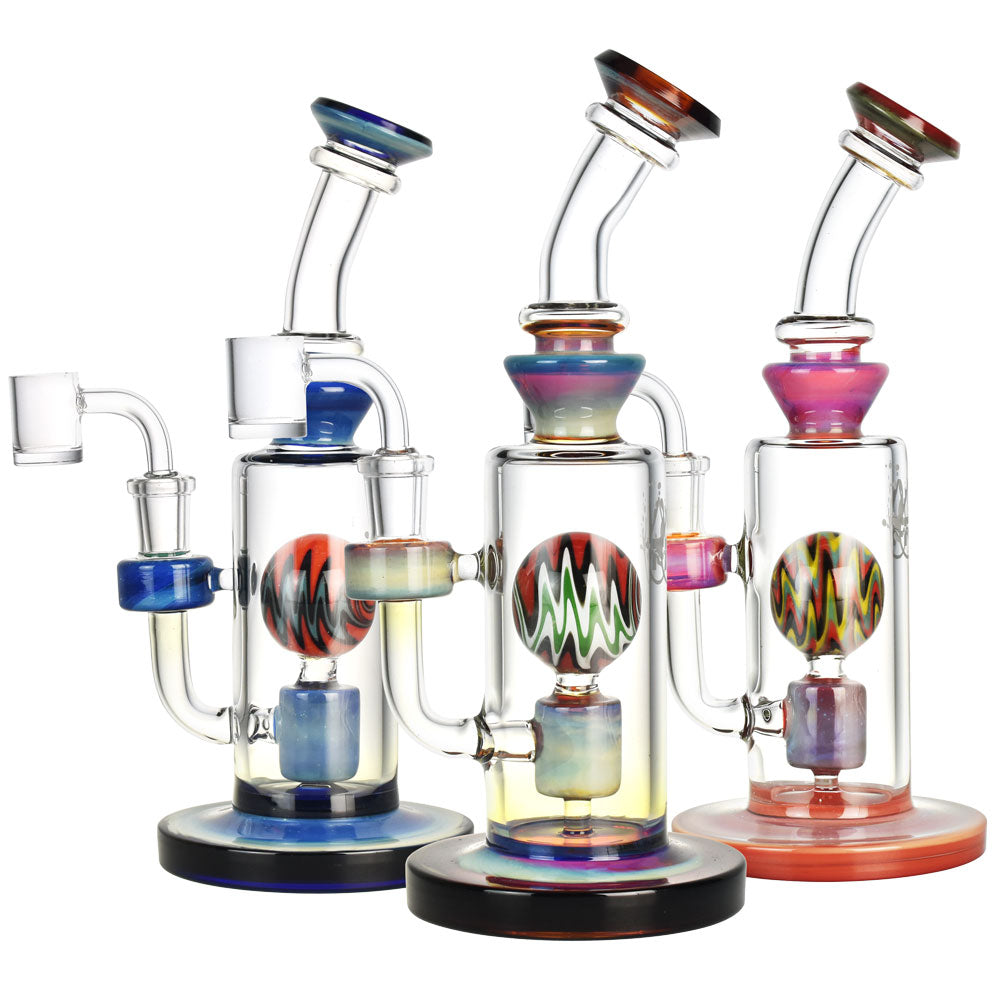 Front view of the Jupiter Atmosphere Dab Rig, a clear glass rig with colorful accents and a rounded base on a black surface. Front view of the Jupiter Atmosphere Dab Rig, a clear glass rig with colorful accents and a rounded base on a black surface.