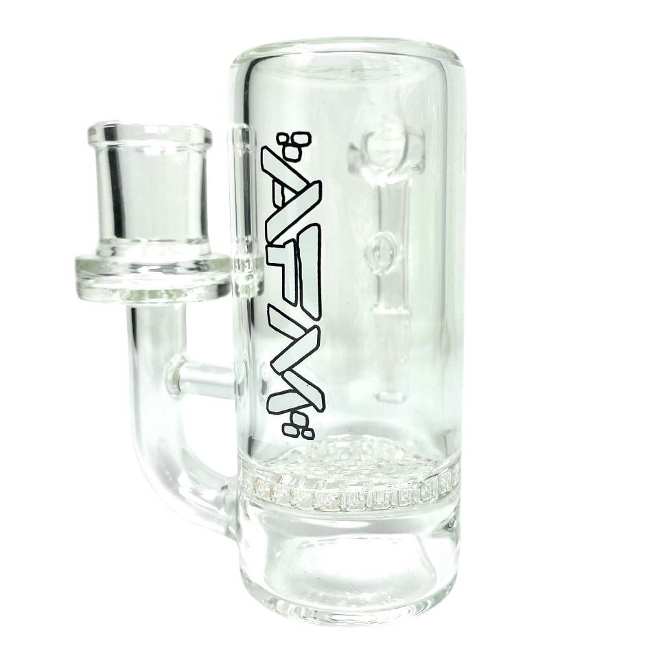 A close-up, angled view of the Honeycomb Perc Glass Ashcatcher, showing its clear glass construction and intricate honeycomb diffusion design. A close-up, angled view of the Honeycomb Perc Glass Ashcatcher, showing its clear glass construction and intricate honeycomb diffusion design.