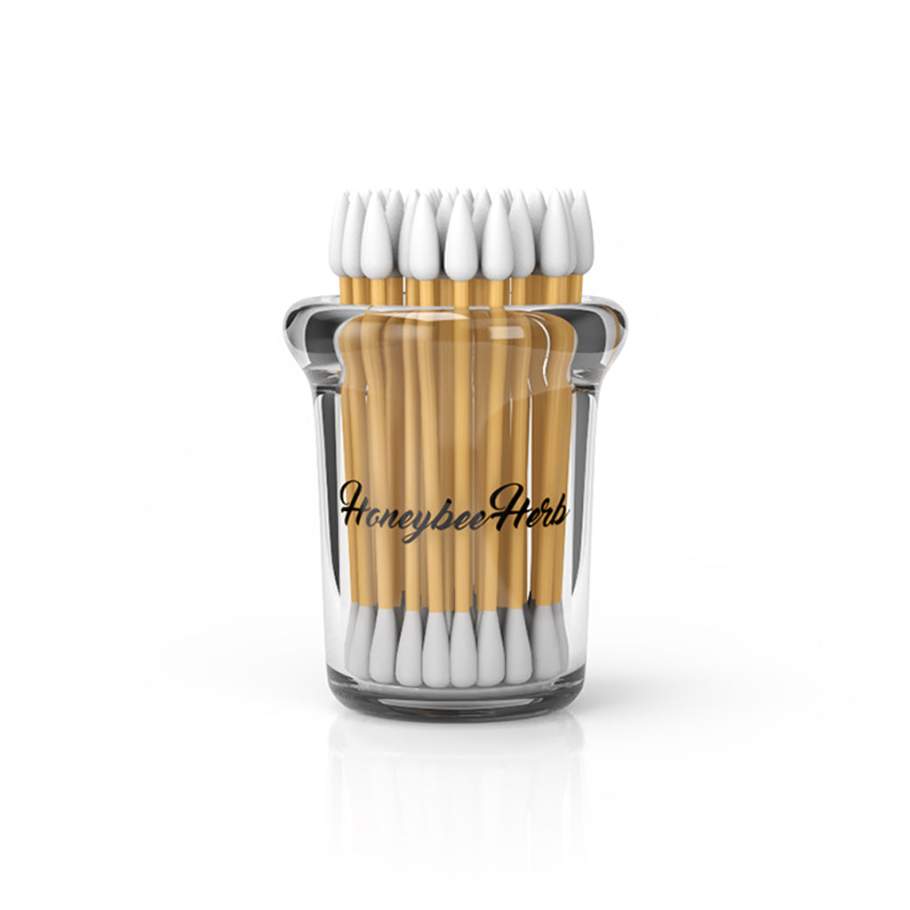 The Dab Swab Holder Jar is shown in a clear glass container filled with white cotton swabs in a bright studio setting. The Dab Swab Holder Jar is shown in a clear glass container filled with white cotton swabs in a bright studio setting.