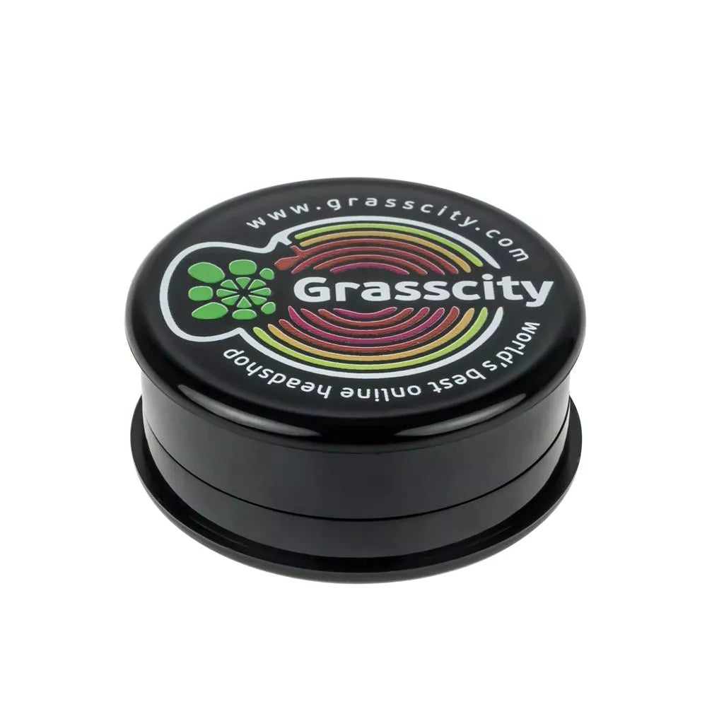 Front view of the Plastic Magnetic 3-Part Herb Grinder, a closed, cylindrical device with metallic accents. Front view of the Plastic Magnetic 3-Part Herb Grinder, a closed, cylindrical device with metallic accents.