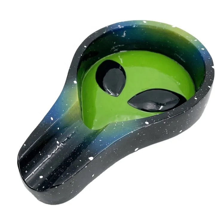 The Alien Ashtray is pictured from a high angle, showcasing its dark, glossy finish and curved shape. The Alien Ashtray is pictured from a high angle, showcasing its dark, glossy finish and curved shape.