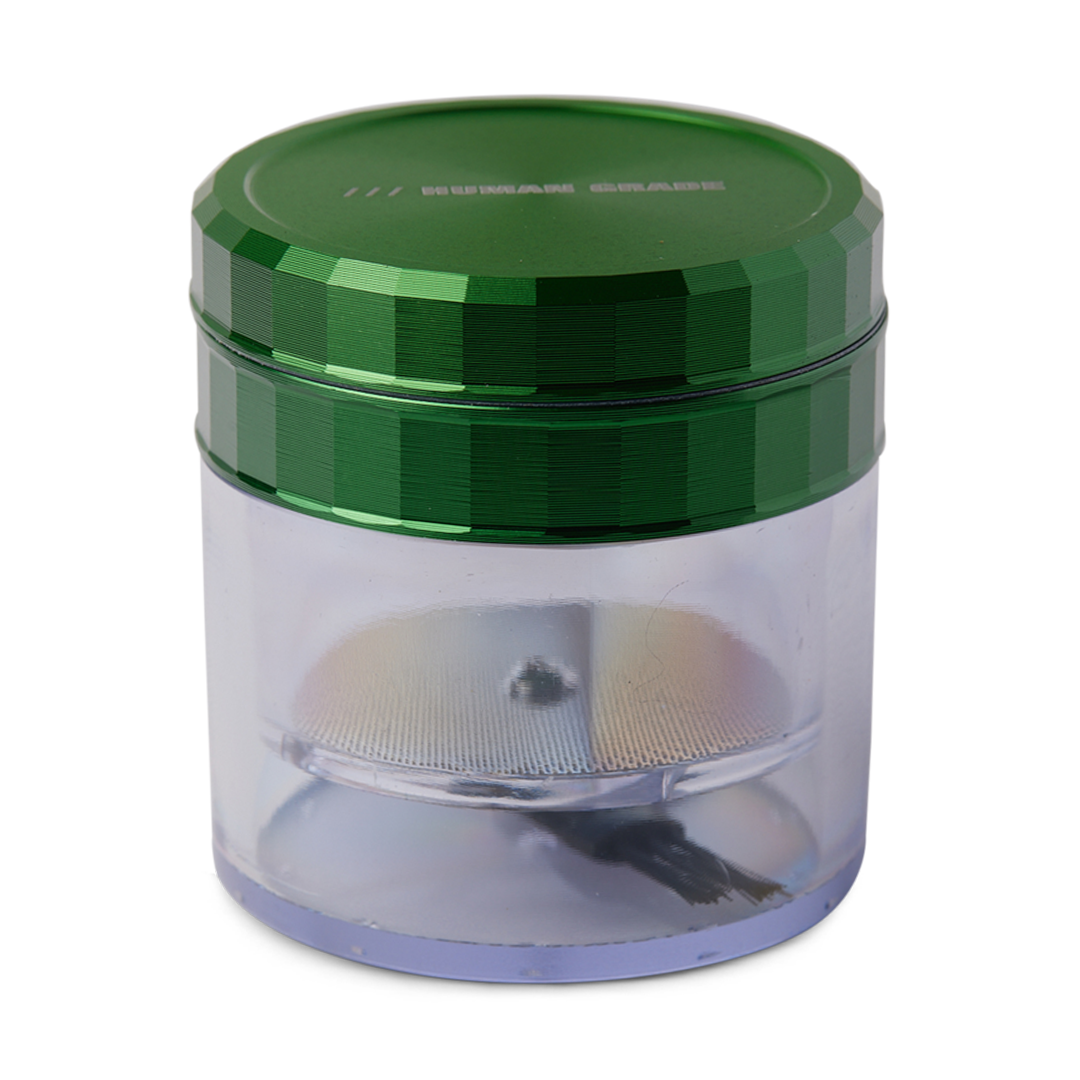 A close-up, angled view of the Storage Grinder 1A with a metallic grinding mechanism visible inside its clear plastic container. A close-up, angled view of the Storage Grinder 1A with a metallic grinding mechanism visible inside its clear plastic container.