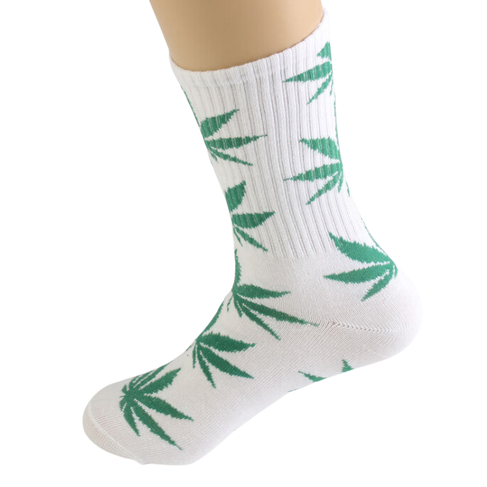A close-up, angled view showcases the Cannabis Leaf Cotton Crew Socks on a foot, displaying a repeating leaf pattern. A close-up, angled view showcases the Cannabis Leaf Cotton Crew Socks on a foot, displaying a repeating leaf pattern.