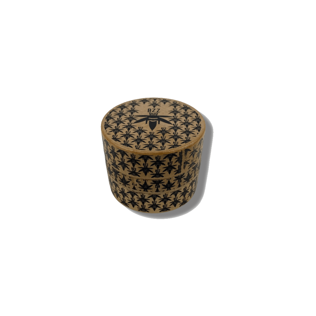 Front view of The Bzz Grinder, a metal grinder with a patterned design against a plain white backdrop. Front view of The Bzz Grinder, a metal grinder with a patterned design against a plain white backdrop.