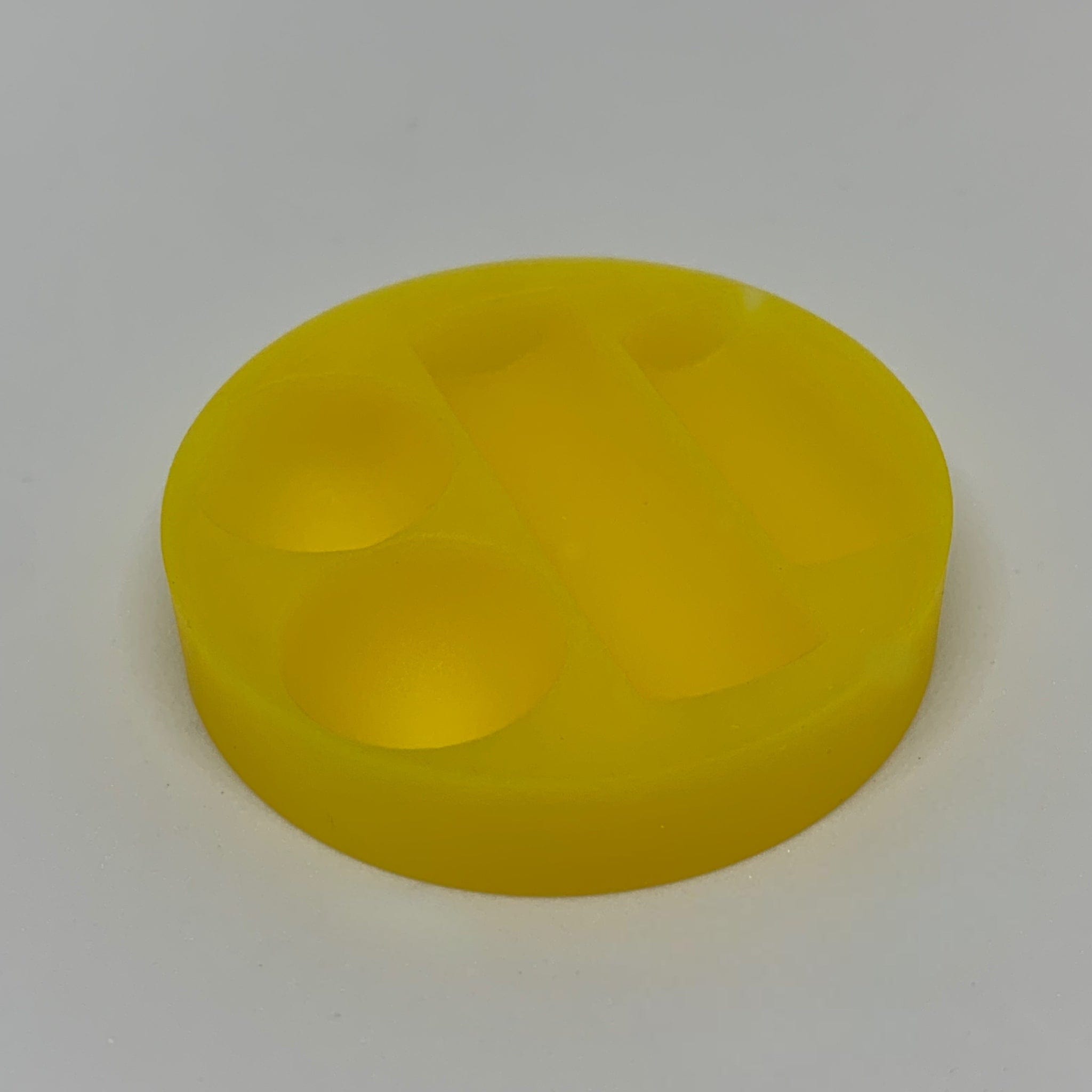 Overhead view of the Dabber Dock Terp Tray, a circular, yellow accessory with a smooth, reflective surface. Overhead view of the Dabber Dock Terp Tray, a circular, yellow accessory with a smooth, reflective surface.