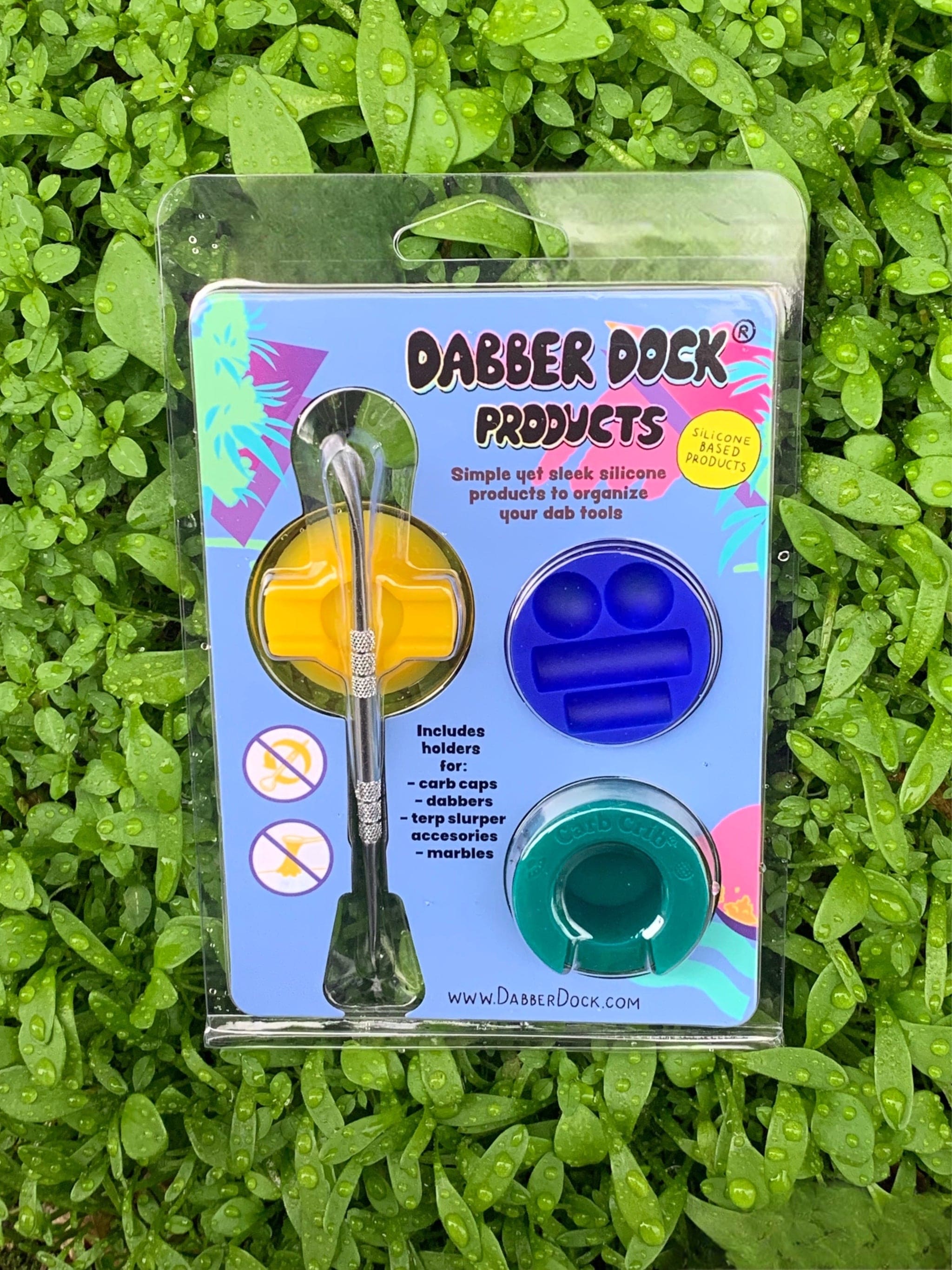 A close-up shot of the Dabber Dock New Drop 3-pack, showcasing the silicone containers arranged on a textured surface. A close-up shot of the Dabber Dock New Drop 3-pack, showcasing the silicone containers arranged on a textured surface.