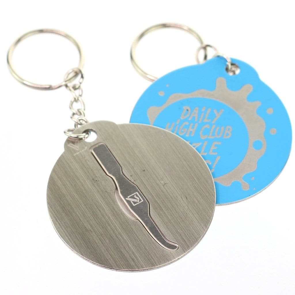 A close-up shot of the Keychain Dabber, showing its blue surface and key ring attached, angled slightly against a plain white background. A close-up shot of the Keychain Dabber, showing its blue surface and key ring attached, angled slightly against a plain white background.