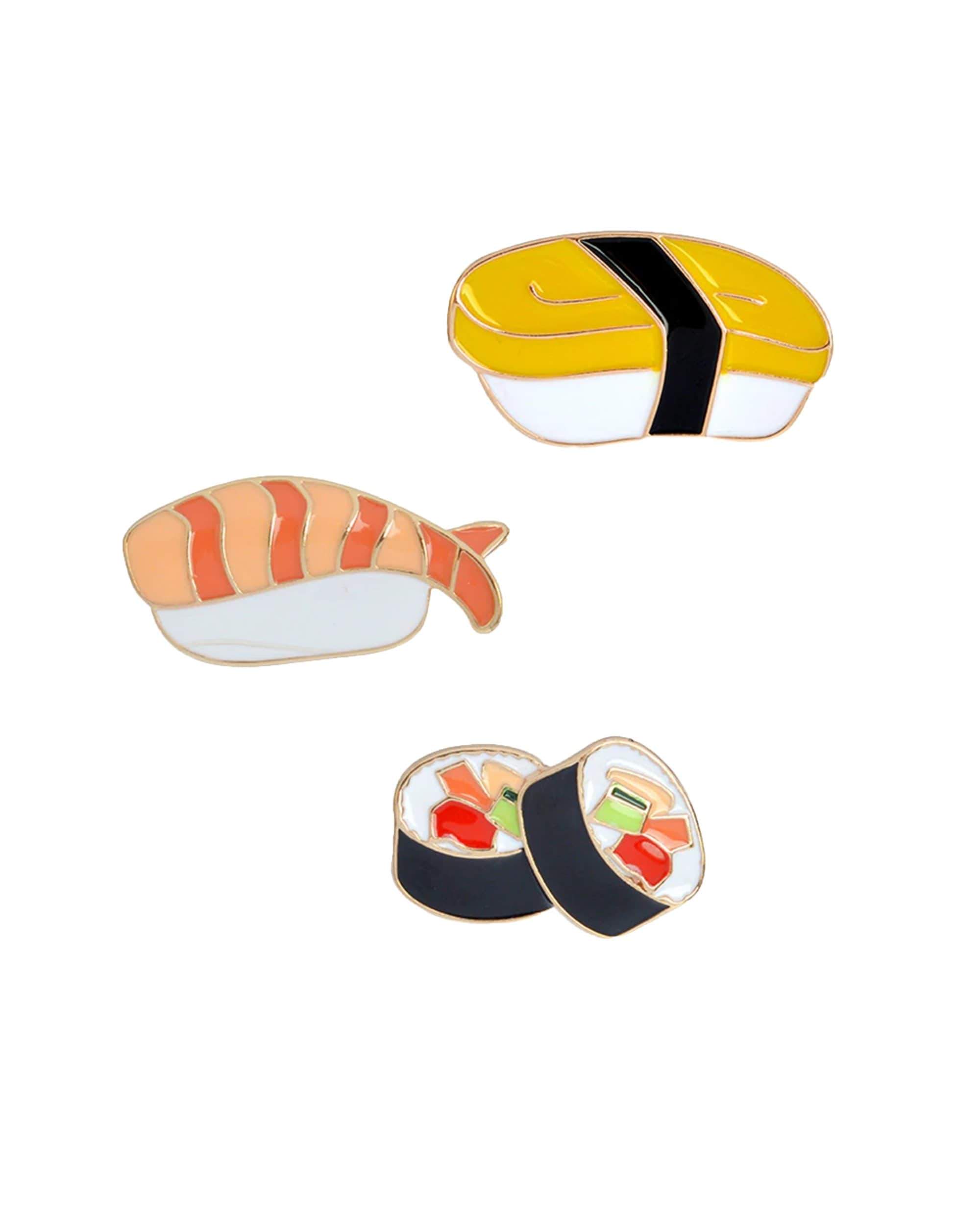 A flat lay shows the Sushi Enamel Pin 3 Pack arranged as three colorful, cartoon-style sushi pieces on a white background. A flat lay shows the Sushi Enamel Pin 3 Pack arranged as three colorful, cartoon-style sushi pieces on a white background.