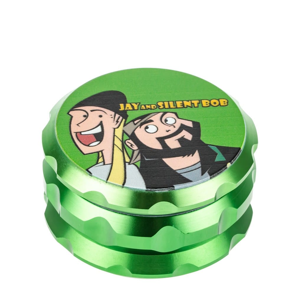 A close-up of the Jay and Silent Bob Grinder, showcasing its multi-tiered, metallic green design from a slightly angled, top-down view. A close-up of the Jay and Silent Bob Grinder, showcasing its multi-tiered, metallic green design from a slightly angled, top-down view.