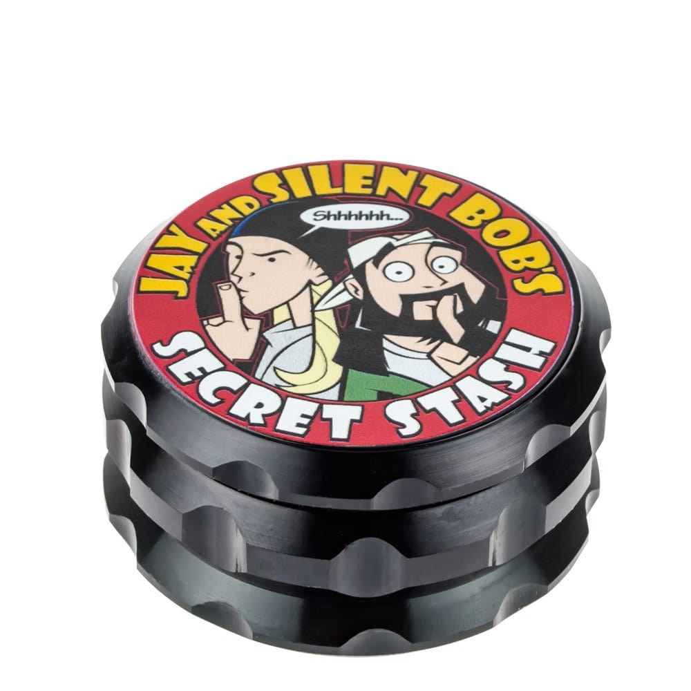 Front view of the Jay and Silent Bob's Secret Stash Grinder, a dark-colored, multi-tiered metal grinder with a circular shape. Front view of the Jay and Silent Bob's Secret Stash Grinder, a dark-colored, multi-tiered metal grinder with a circular shape.
