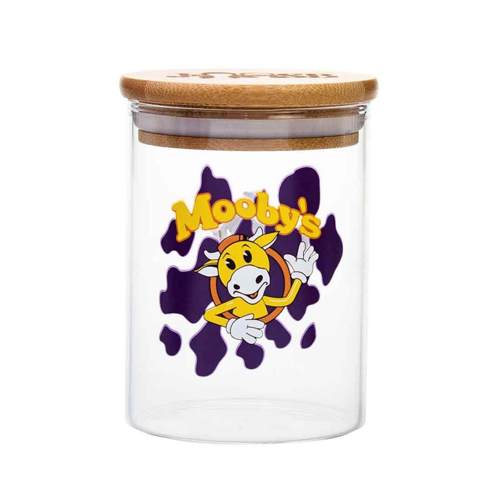 Front view of the Mooby's Stash Jar, a clear glass container with a cartoon cow design and a wooden lid. Front view of the Mooby's Stash Jar, a clear glass container with a cartoon cow design and a wooden lid.