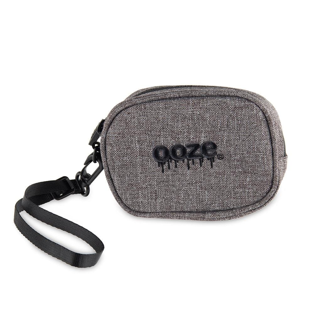 A close-up, angled view of the Traveler Smell Proof Wristlet, featuring a gray textured exterior and black wrist strap. A close-up, angled view of the Traveler Smell Proof Wristlet, featuring a gray textured exterior and black wrist strap.