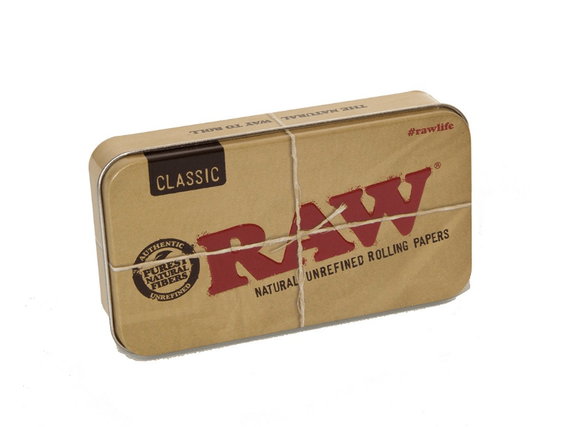 Close-up of the RAW Tin Travel Case with the brand logo prominently displayed on its metallic silver surface. Close-up of the RAW Tin Travel Case with the brand logo prominently displayed on its metallic silver surface.