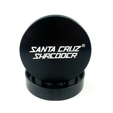 A front view of the Santa Cruz Shredder Premium Grinder (2-part) Large (2 3/4") with a metallic gray finish, positioned against a dark background. A front view of the Santa Cruz Shredder Premium Grinder (2-part) Large (2 3/4") with a metallic gray finish, positioned against a dark background.