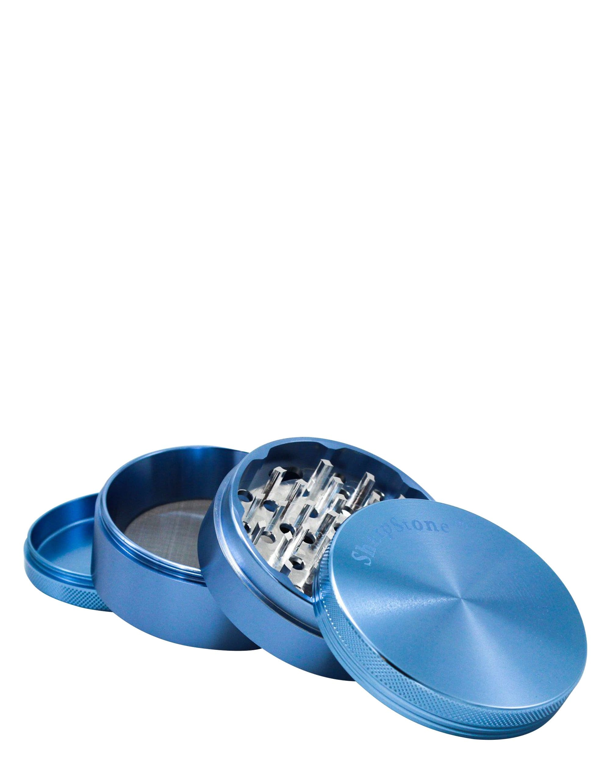 A slightly angled close-up of the Classic 4 Piece Hard Top Grinder, showcasing its metallic blue finish and open lid with grinding teeth. A slightly angled close-up of the Classic 4 Piece Hard Top Grinder, showcasing its metallic blue finish and open lid with grinding teeth.