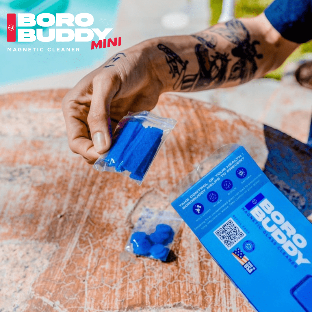 A close-up shows the blue BoroBuddy Mini Cleaning Pads stacked against a blurred, dark background. A close-up shows the blue BoroBuddy Mini Cleaning Pads stacked against a blurred, dark background.