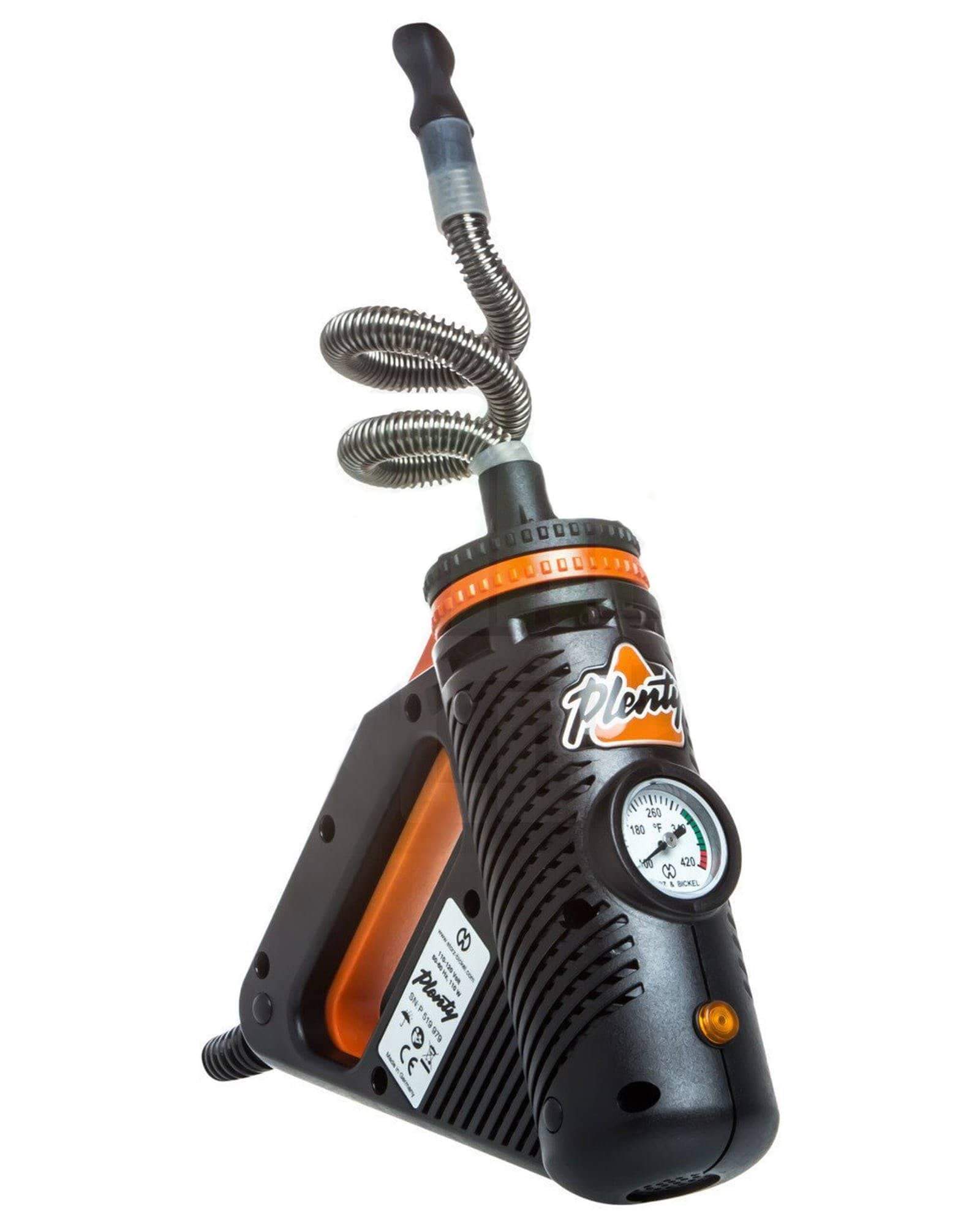 A front view of the Plenty Vaporizer, showing a black handheld device with a gauge and coiled hose. A front view of the Plenty Vaporizer, showing a black handheld device with a gauge and coiled hose.