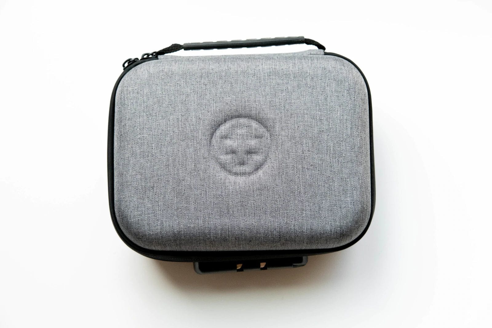 Overhead view of The Very Happy Kit, a black rectangular case with a zippered closure against a neutral background. Overhead view of The Very Happy Kit, a black rectangular case with a zippered closure against a neutral background.