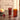 Close-up of the red glass pieces on a dark stone countertop, featuring the NWTN Home Deco Gravity Pipe beside a matching ribbed tumbler.