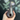 A hand holds the dark-colored Baby Elephant Sherlock Pipe, showcasing its curved shape and smooth finish against a blurred background.