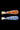 Side view of two 3 in. DankStop Piped and Fumed One Hitter glass pipes, one with orange internal twist and one with blue, on black.