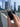 A hand holds the black Stage 2 Joint Case against a blurred city skyline, showcasing its cylindrical shape.