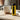 Right-side view of the yellow Ooze Drought Dry Herb Vaporizer standing upright on a wooden table beside a steaming white mug.