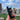 A close-up shows the Stage 1 Joint Case held against a blurred city background, displaying its sleek, dark design.