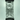 Vertical close-up of the Prism Flower Power Beaker Double Stack showing the clear glass double-chamber percolator and black banded connectors against a soft backlit background