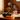 Diagonal close-up of a green Pulsar 510 DL Pipe Variable Voltage Cartridge Vape resting on a wooden desk beside books and a steaming teacup