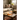 Natural light side view of the Cloud Cali Inc DankStop 8-inch Showerhead Dual-Use Water Pipe w/ Colored Accents with red rim accents on a wooden coffee table beside books and a small succulent