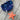 Close-up of the Starfish Pipe, a bright orange, star-shaped smoking pipe against a rustic wooden background.