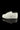 A side view of the Sneaker Pipe, resembling a white sneaker sole, is displayed on a reflective black surface.