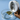 Close-up of the Grinder with ground cannabis inside a clear glass dish on a wooden surface.