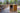 The Bzz Ritual Box is open on a wooden surface, revealing its interior against a blurred, green background.