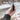 A hand holds the silver Trio Vaporizer against a blurred, out-of-focus background.