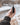 A hand holds the silver Trio Vaporizer against a blurred, out-of-focus background.